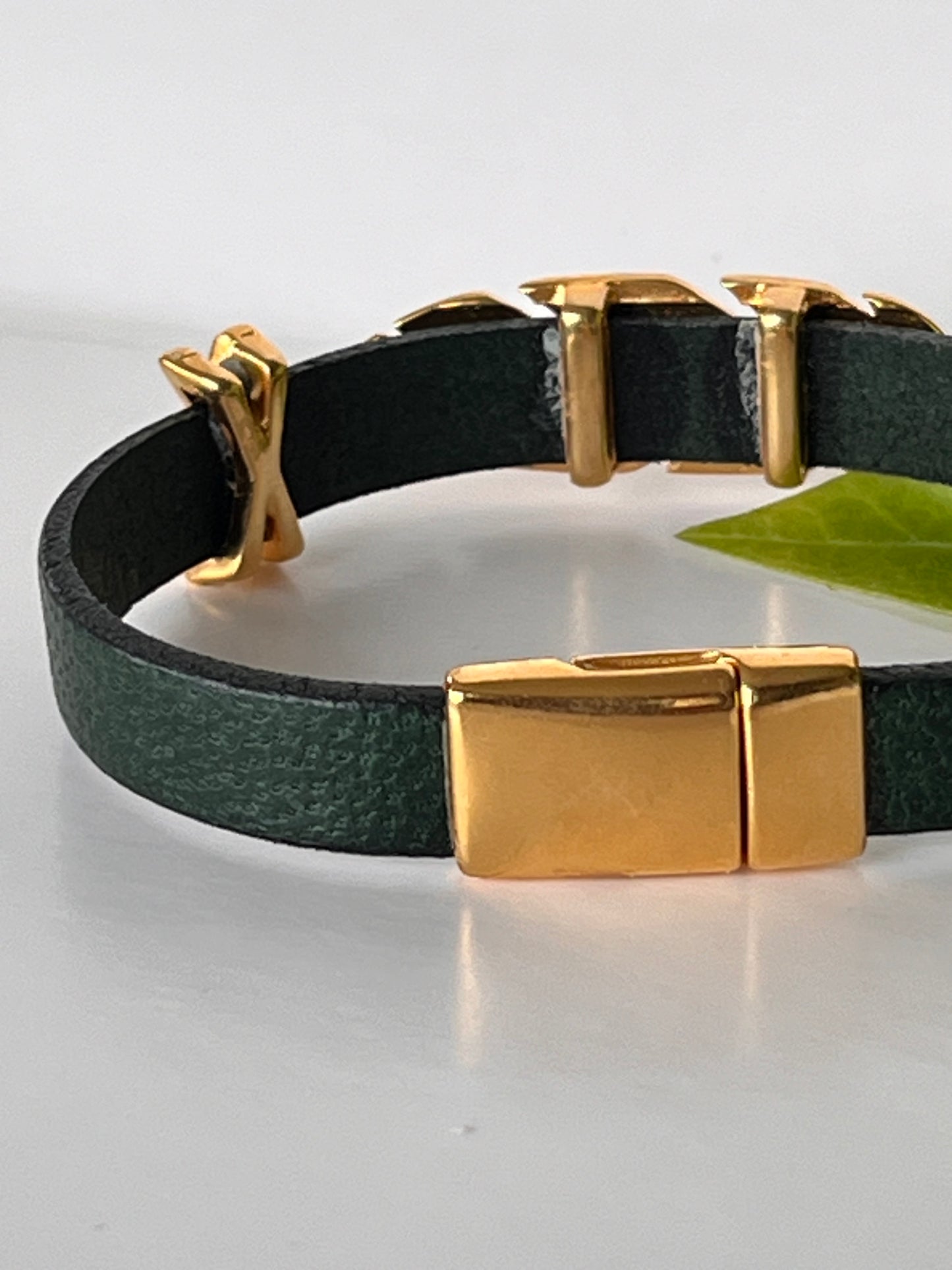 Flaskegrønt lær med gulldetaljer